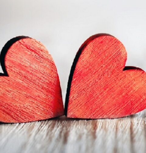 Valentines day background with two red hearts on wooden background