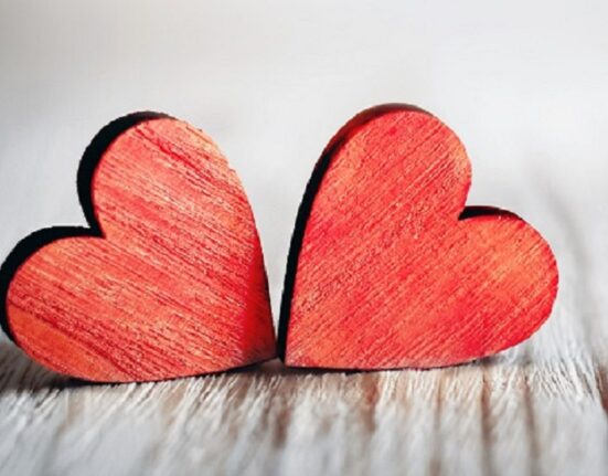 Valentines day background with two red hearts on wooden background