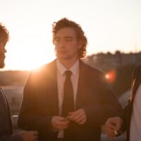 Three men are showing off their suits.