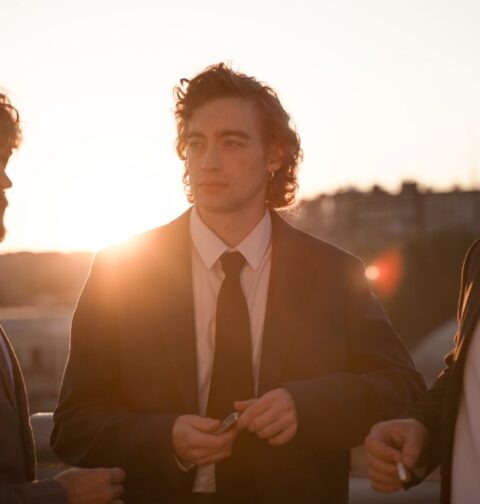 Three men are showing off their suits.